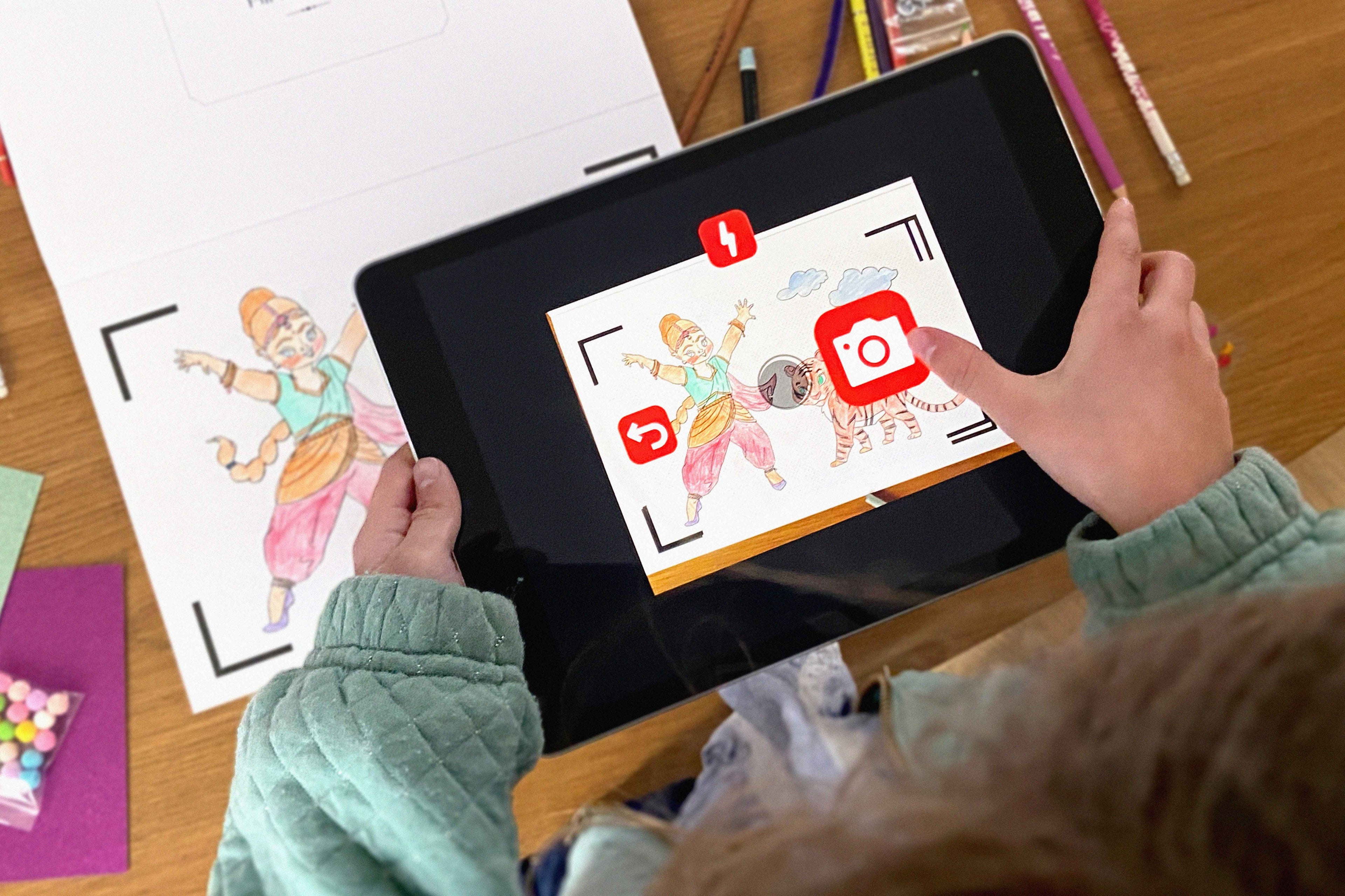 Enfant utilisant une tablette pour scanner un dessin colorié du livre Les Princesses - BlinkBook et l’animer en dessin animé.